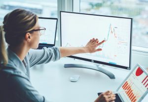 Das Bild zeigt eine Bankfrau mit Blick auf den Monitor und deutlichem Ergebnisbilanz zu den schwierigen Zeiten der Unternehmensfinanzierung für Nachfolge.