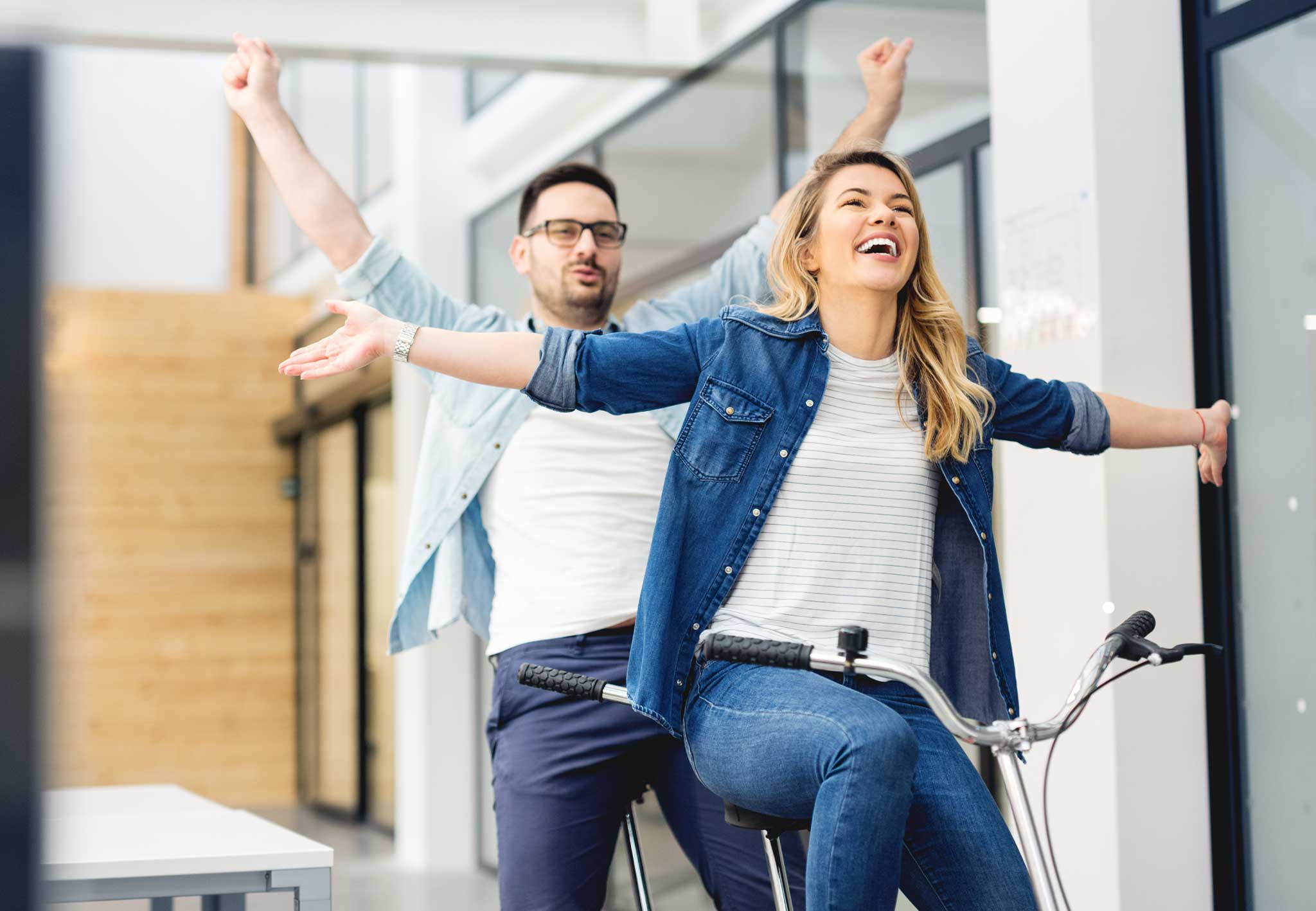 Trend 2026 in der Finanzierung sind hybride Finanzierungen, wie das Bild mit den beiden Jungunternehmern auf dem Doppelfahrrad zeigt.