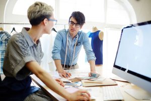 Zwei Personen besprechen Unterlagen am Schreibtisch – Beratung zu Finanzierung und stillem Beteiligungskapital für KMU.