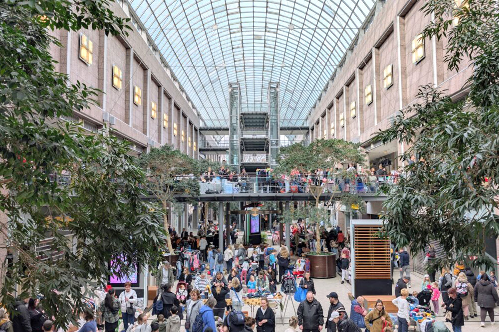 Belebtes Atrium einer Konferenzlocation mit vielen Besucher:innen – Auszeichnung für Green City Solutions bei UN-Tourismus-Konferenz zur urbanen Hitzeminderung und Luftreinigung.